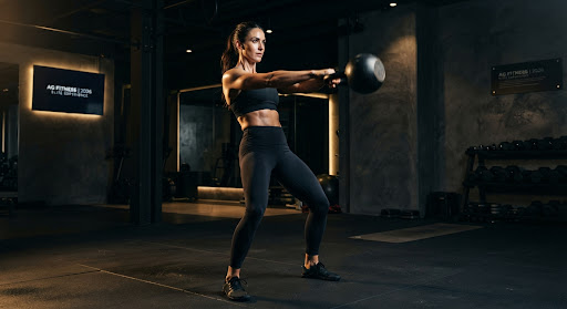 Woman athlete performing kettlebell swing
